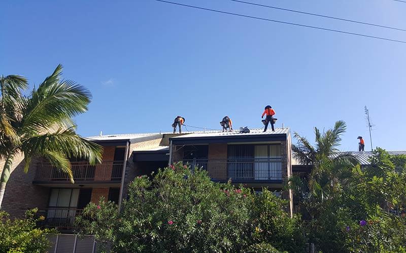 rope-access-workers-painting-roof-of-tall-building